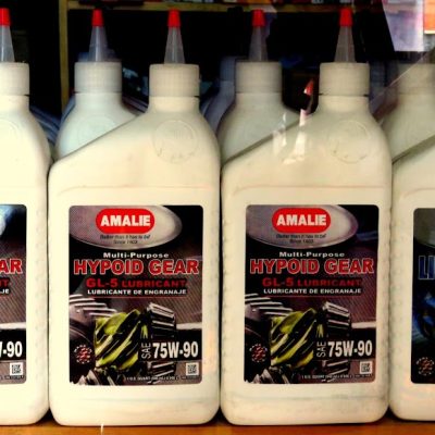 Botellas de lubricante Amalie Hypoid Gear GL-5 y Limited Slip 75W-90 en vitrina de tienda de repuestos