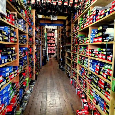Estanterías llenas de repuestos automotrices en pasillo de tienda Elgueta & Vásquez en Valdivia